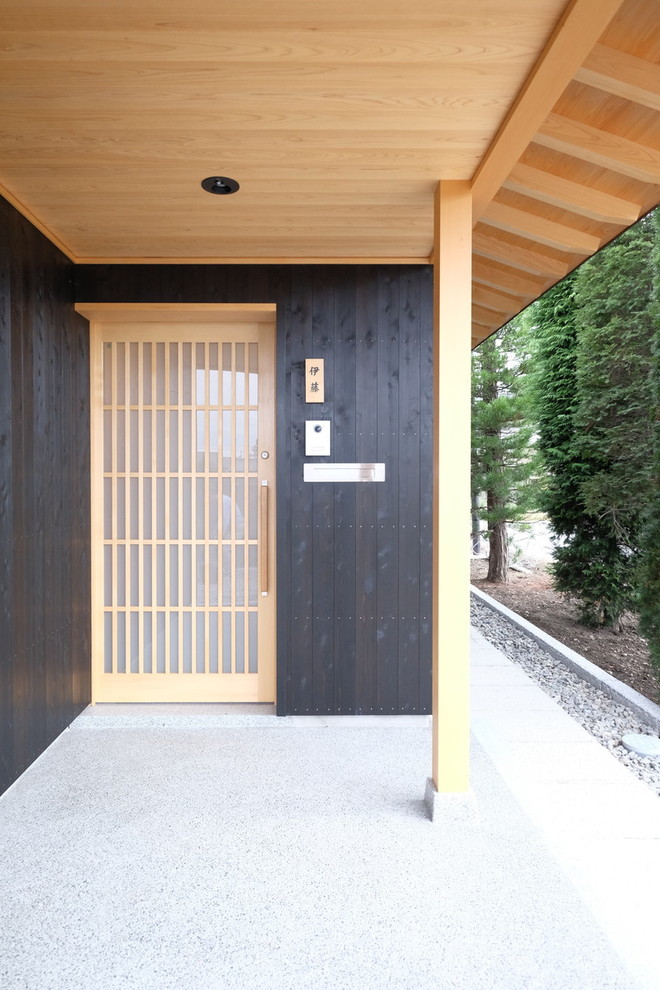 Стильный дизайн: маленькая входная дверь в восточном стиле с черными стенами, гранитным полом, входной дверью из светлого дерева, раздвижной входной дверью и серым полом для на участке и в саду - последний тренд
