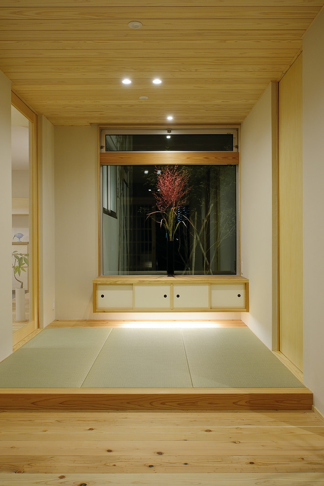 Imagen de hall escandinavo grande con madera, paredes blancas, tatami, puerta corredera, puerta de madera en tonos medios, suelo verde y papel pintado