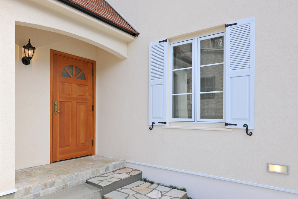Exemple d'une porte d'entrée chic avec un mur beige, une porte simple et une porte en bois brun.