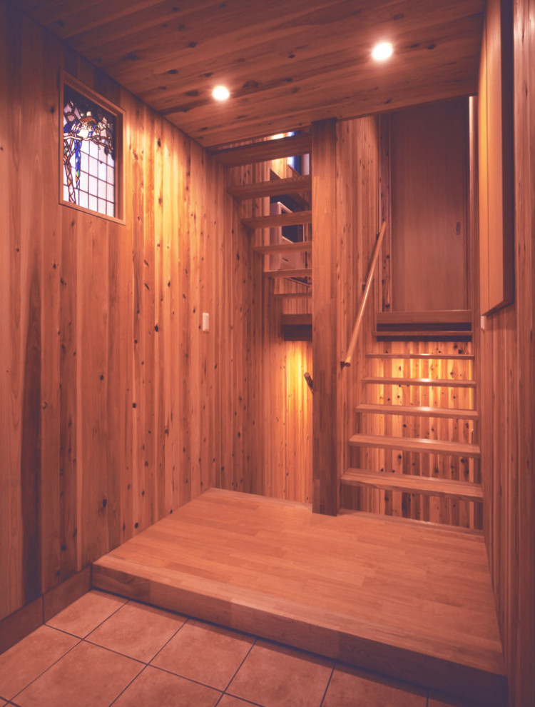 Aménagement d'une petite entrée scandinave avec un couloir, un mur beige, un sol en bois brun, une porte simple, une porte en bois clair, un sol beige, un plafond en bois et boiseries.
