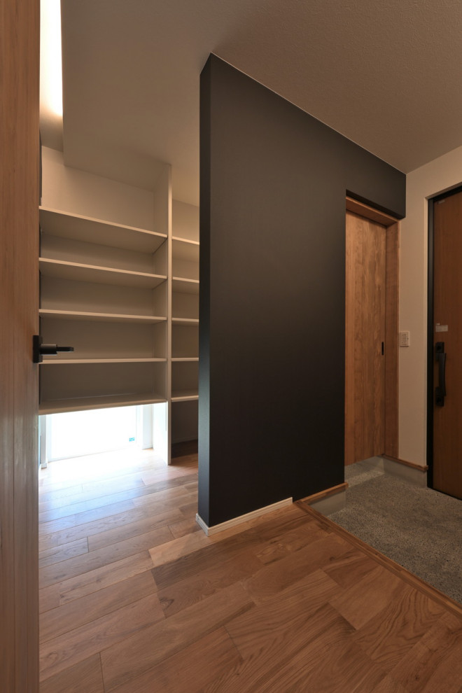 Inspiration för moderna entréer, med svarta väggar, mörkt trägolv, en tvådelad stalldörr, en brun dörr och beiget golv