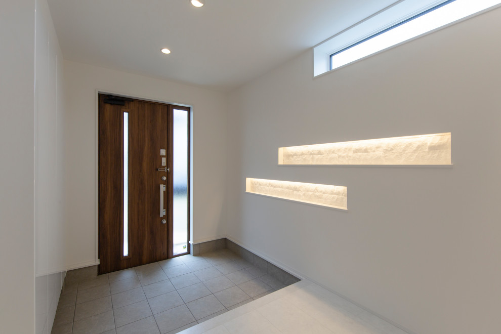 Immagine di un piccolo corridoio minimalista con pareti bianche, pavimento con piastrelle in ceramica, una porta singola, una porta in legno scuro e pavimento bianco