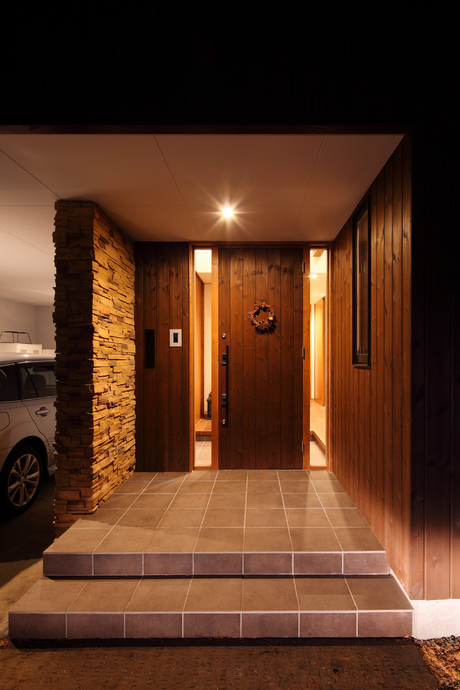 他の地域にある中くらいなモダンスタイルのおしゃれな玄関 (茶色い壁、セラミックタイルの床、茶色いドア、グレーの床) の写真