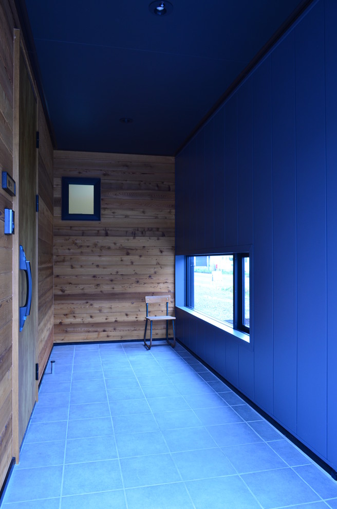 Diseño de distribuidor nórdico pequeño con paredes blancas, suelo de baldosas de cerámica, puerta simple, puerta de madera en tonos medios y suelo gris