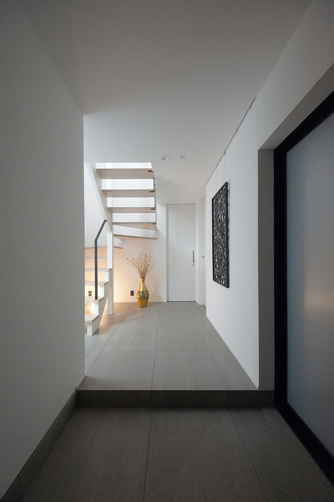 Ispirazione per un ingresso con vestibolo minimalista di medie dimensioni con pareti bianche