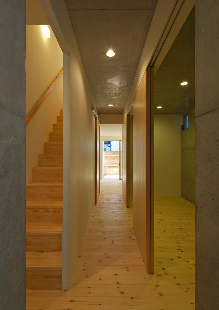 Entryway - mid-sized modern light wood floor and brown floor entryway idea in Osaka with white walls