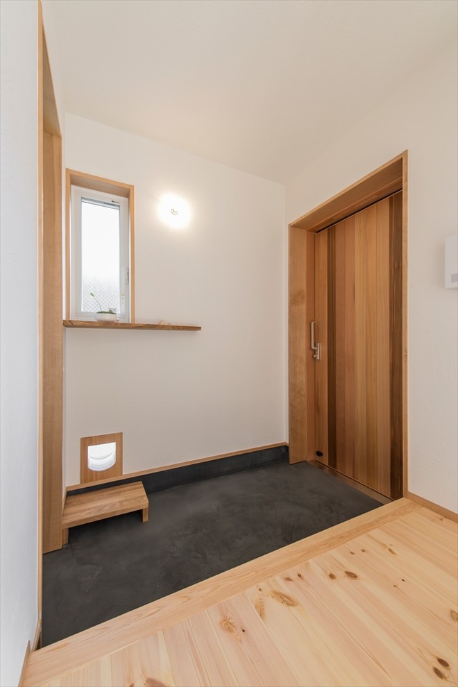 This is an example of a scandi entrance in Yokohama with white walls, a single front door, a medium wood front door and grey floors.