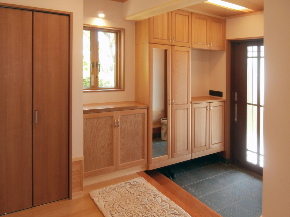Источник вдохновения для домашнего уюта: узкая прихожая среднего размера в стиле модернизм с белыми стенами, полом из керамогранита, раздвижной входной дверью, входной дверью из темного дерева и черным полом