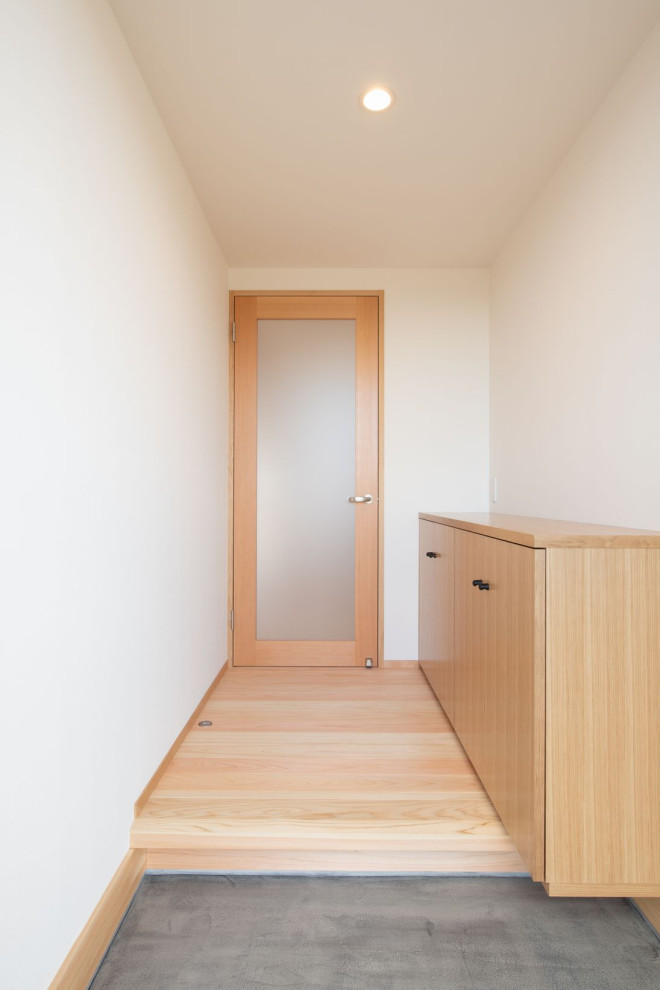 Immagine di un corridoio scandinavo di medie dimensioni con pareti bianche, pavimento in legno massello medio, una porta singola, una porta in metallo e pavimento beige