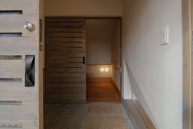 Idee per un ingresso o corridoio con pareti beige, una porta scorrevole e una porta in legno chiaro
