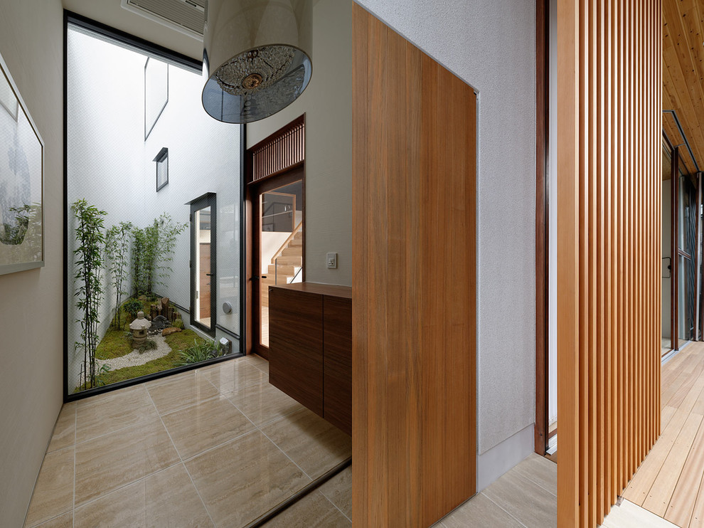 Exemple d'une entrée tendance avec un mur blanc, un sol en travertin, une porte simple, une porte en bois foncé et un sol beige.