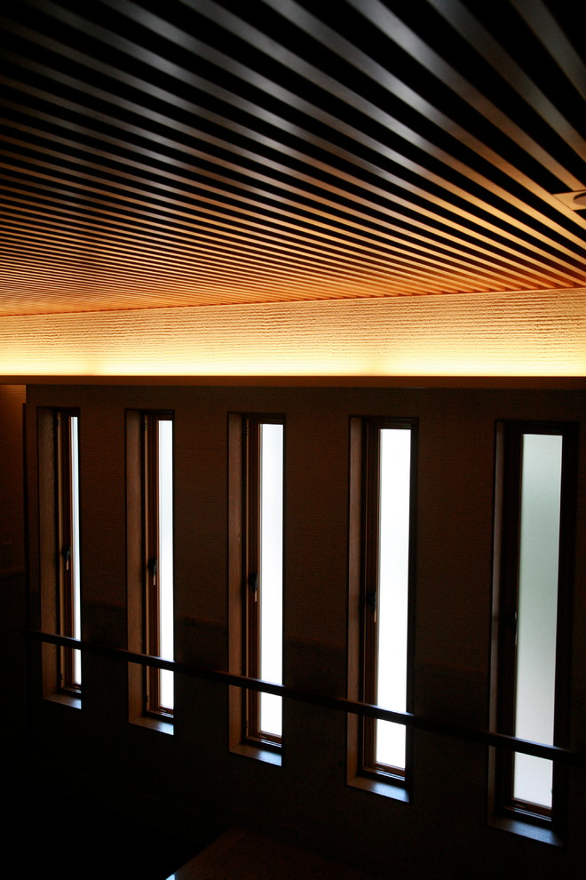 Immagine di un grande ingresso o corridoio contemporaneo con pareti marroni, pavimento in marmo e pavimento beige