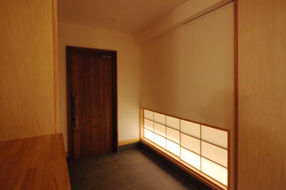 Idee per un corridoio etnico di medie dimensioni con pareti nere, pavimento con piastrelle in ceramica, una porta singola, una porta in legno scuro e pavimento nero