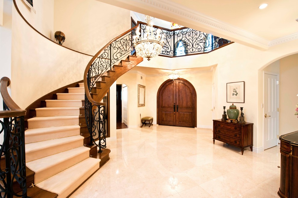 Exempel på en klassisk hall, med beige väggar, marmorgolv, en dubbeldörr, mörk trädörr och beiget golv