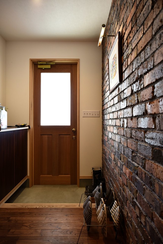 Modelo de hall retro pequeño con paredes multicolor, suelo de cemento, puerta simple, puerta de madera en tonos medios y suelo gris