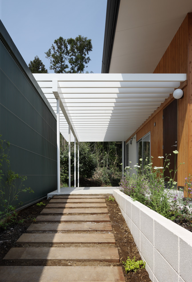 Modelo de terraza vintage en patio delantero con huerto, adoquines de hormigón y pérgola