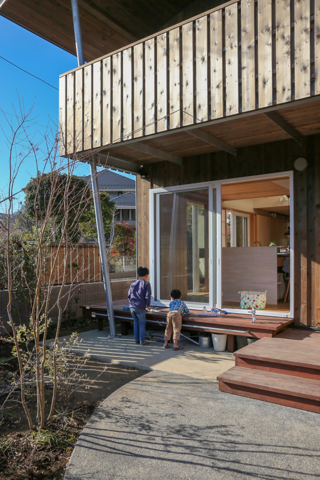 Idée de décoration pour un porche d'entrée de maison asiatique avec une terrasse en bois.