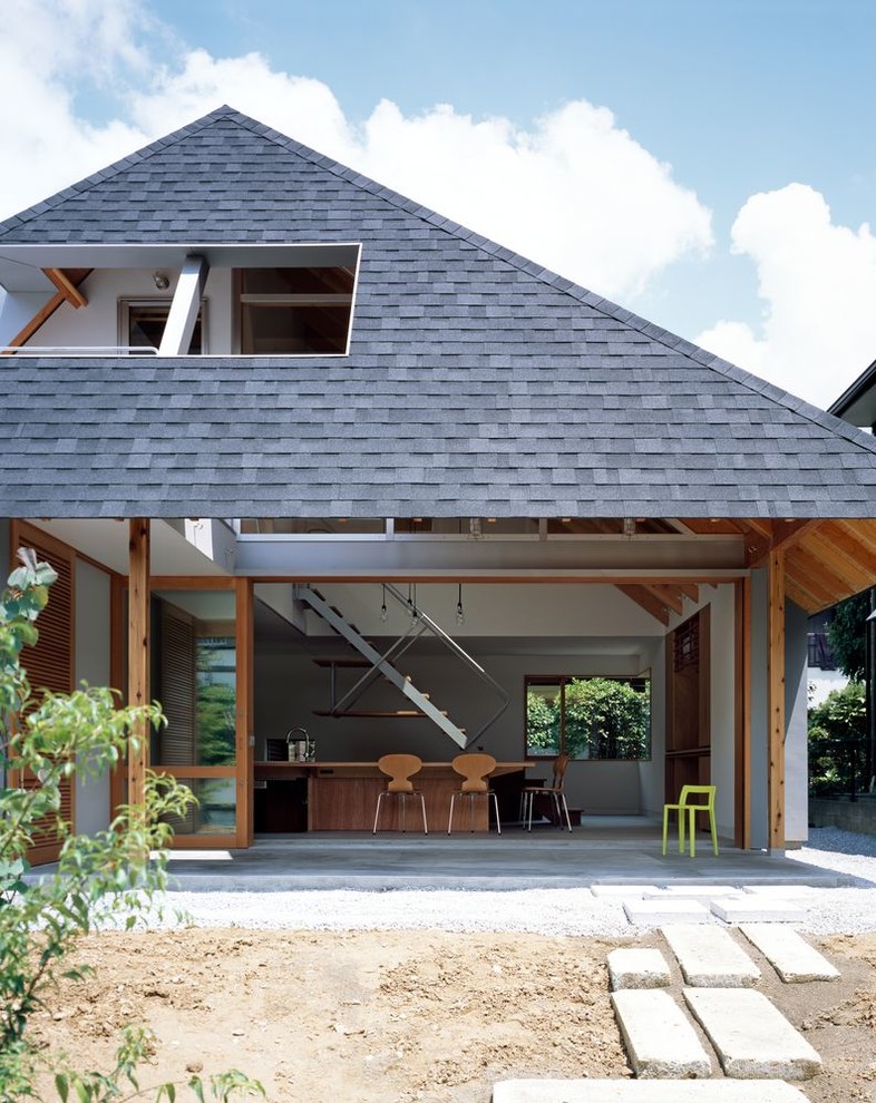 Inspiration pour un porche d'entrée de maison avant minimaliste de taille moyenne avec des pavés en béton et une extension de toiture.