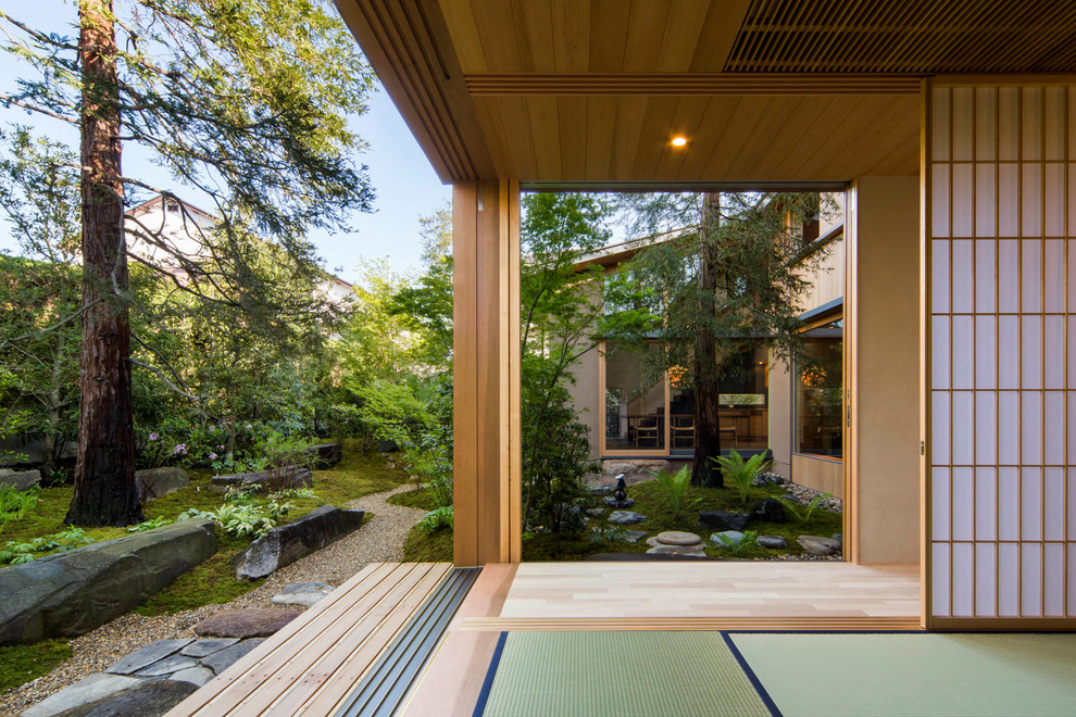 Réalisation d'un porche d'entrée de maison latéral asiatique de taille moyenne avec une terrasse en bois.