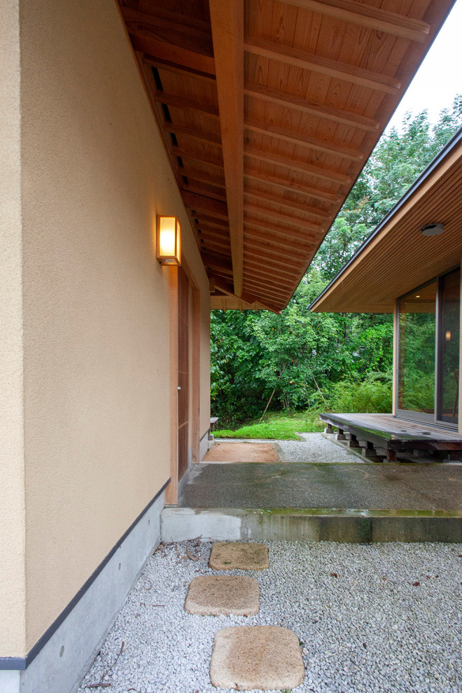 Foto di un portico etnico di medie dimensioni e dietro casa con pavimentazioni in pietra naturale e un tetto a sbalzo
