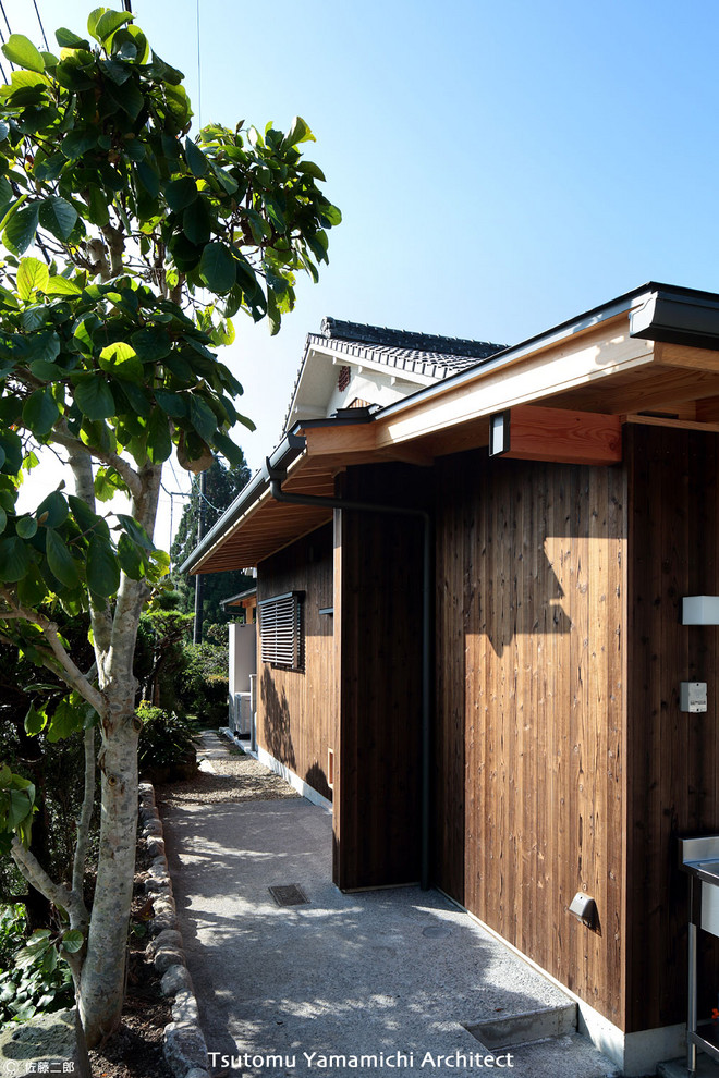 Cette image montre un porche d'entrée de maison avant nordique de taille moyenne avec une extension de toiture, une moustiquaire et des pavés en béton.