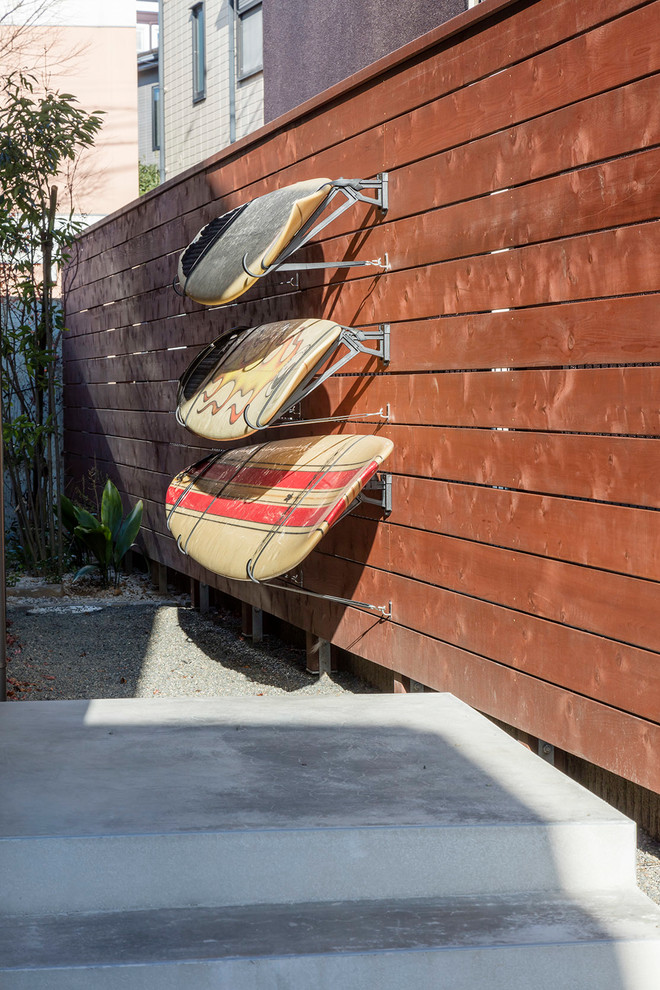 Ejemplo de terraza marinera en patio delantero con adoquines de hormigón