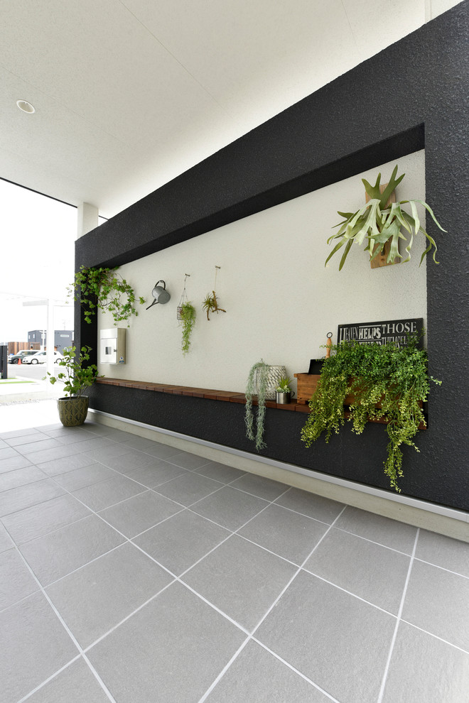 Foto di un portico minimalista con piastrelle e un tetto a sbalzo
