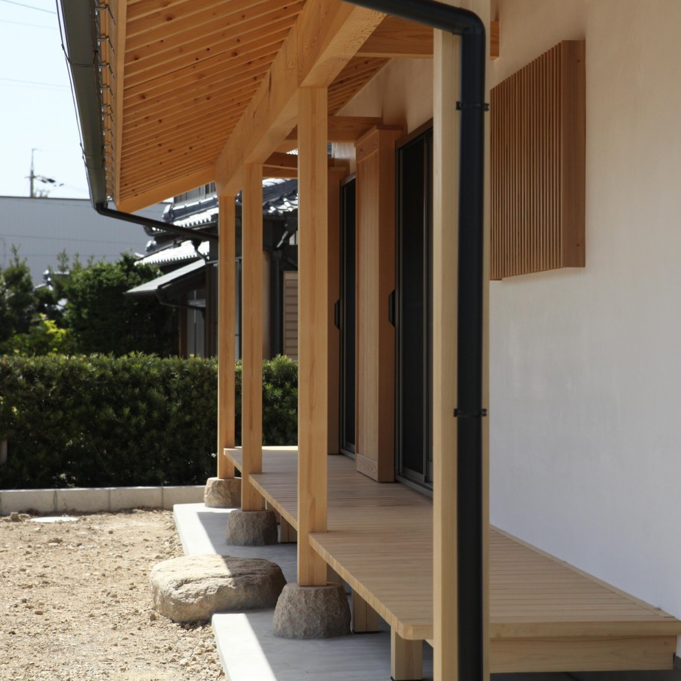 Esempio di un portico etnico di medie dimensioni e davanti casa con un tetto a sbalzo e parapetto in legno