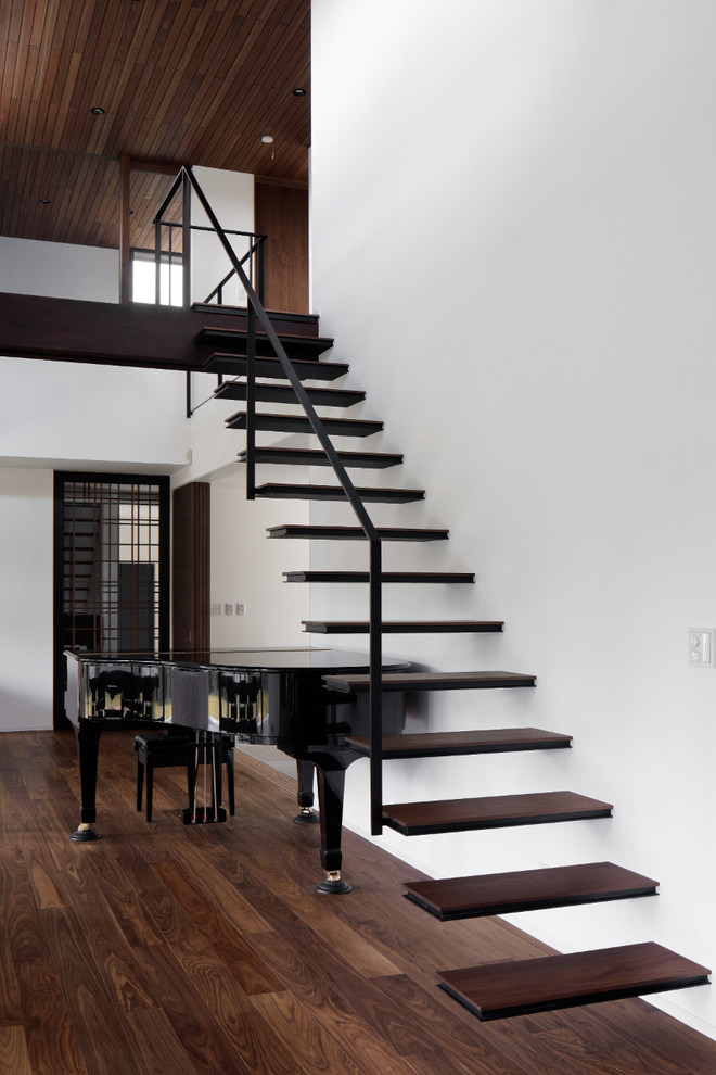 Ejemplo de escalera recta clásica con escalones de madera y barandilla de metal