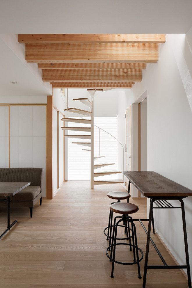 Стильный дизайн: винтовая лестница в восточном стиле с деревянными ступенями и металлическими перилами без подступенок - последний тренд