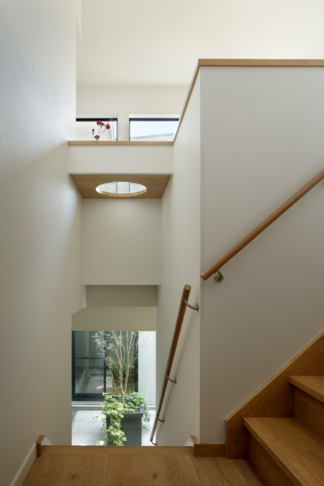 Стильный дизайн: угловая деревянная лестница в стиле модернизм с деревянными ступенями и деревянными перилами - последний тренд