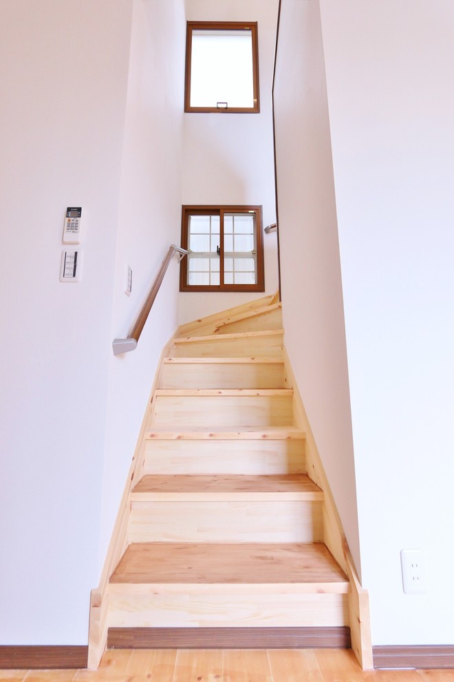 Idée de décoration pour un escalier courbe minimaliste avec des marches en bois et des contremarches en bois.