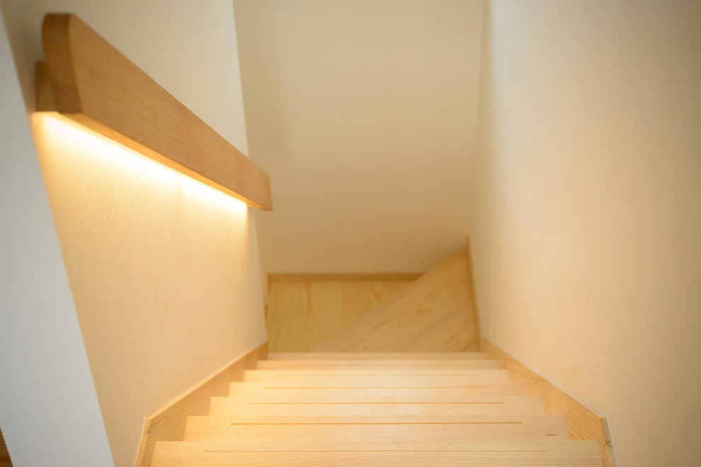 Foto de escalera en U nórdica de tamaño medio con escalones de madera, contrahuellas de madera y barandilla de madera