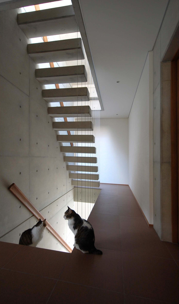 Réalisation d'un escalier sans contremarche flottant minimaliste en béton de taille moyenne avec un garde-corps en bois.