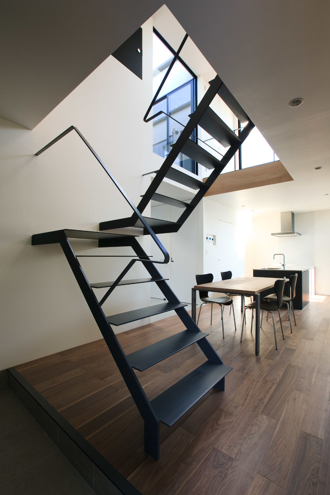 На фото: п-образная лестница среднего размера в стиле модернизм с металлическими ступенями, металлическими перилами и обоями на стенах без подступенок