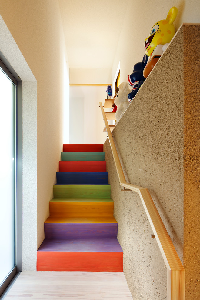 他の地域にあるコンテンポラリースタイルのおしゃれな直階段 (木の蹴込み板、木材の手すり) の写真
