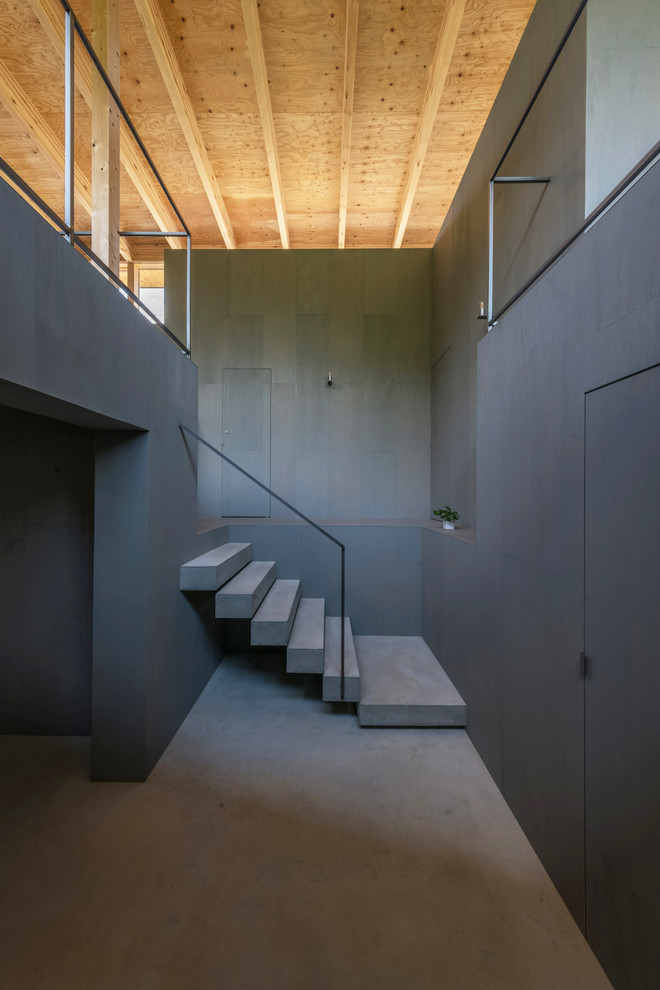 Idées déco pour un escalier droit moderne en béton avec des contremarches en béton et un garde-corps en métal.