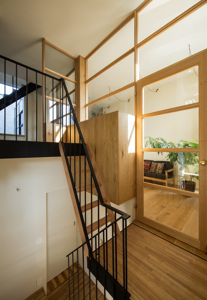 Стильный дизайн: лестница в стиле модернизм с деревянными ступенями и металлическими перилами без подступенок - последний тренд