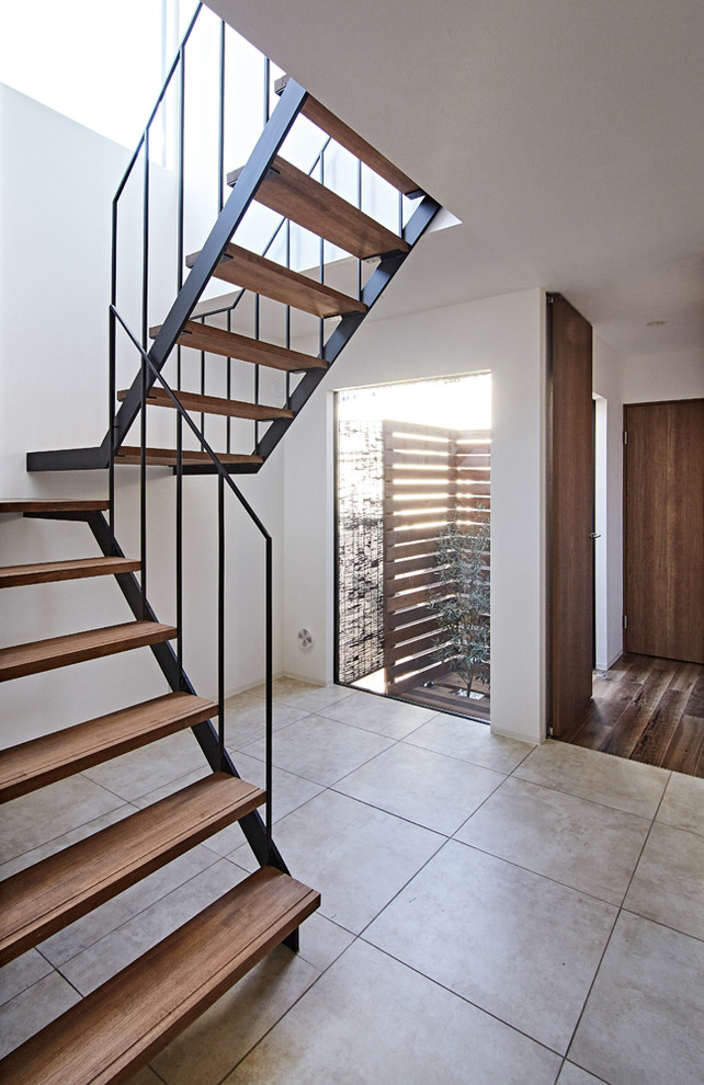 На фото: п-образная лестница среднего размера в современном стиле с деревянными ступенями и металлическими перилами без подступенок с