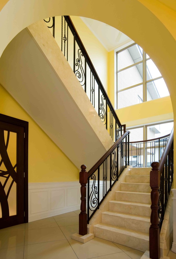 На фото: огромная п-образная лестница в классическом стиле с мраморными ступенями, подступенками из мрамора и перилами из смешанных материалов с