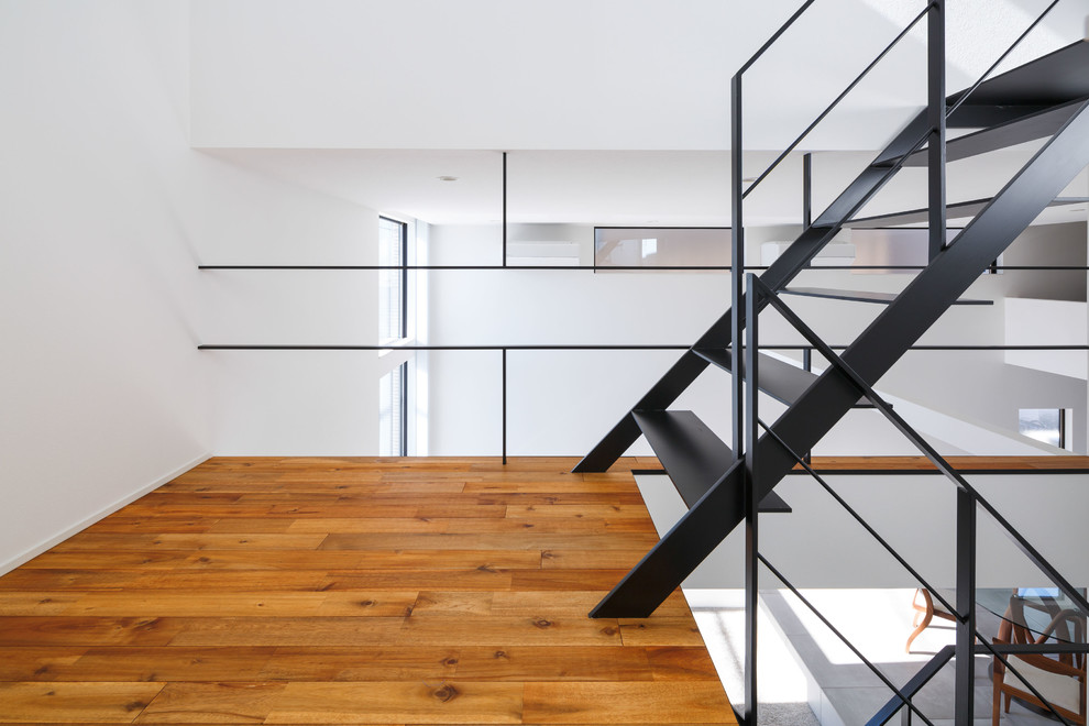 На фото: п-образная металлическая лестница среднего размера в стиле модернизм с металлическими ступенями, металлическими перилами и обоями на стенах с