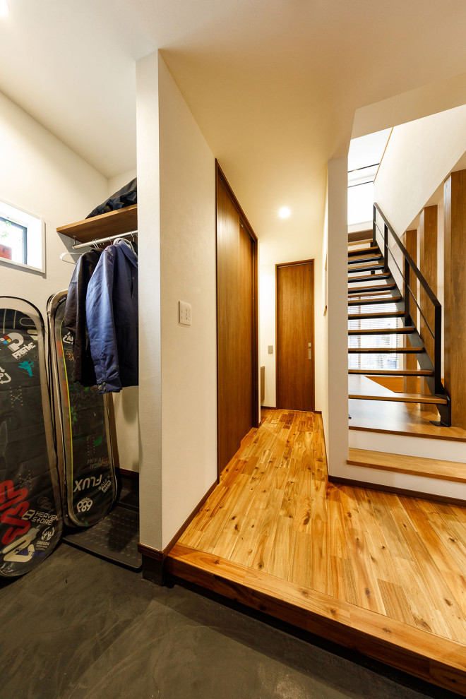 Aménagement d'un escalier sans contremarche droit industriel de taille moyenne avec des marches en bois, un garde-corps en métal et du papier peint.