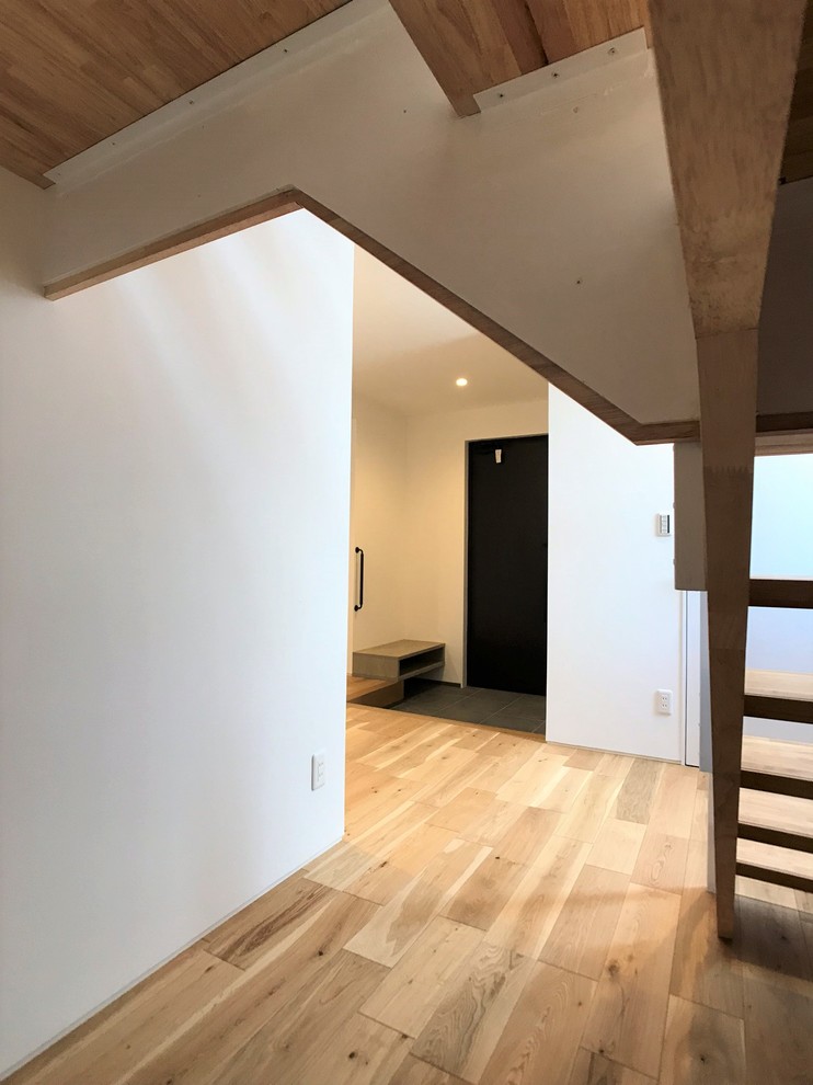 Cette image montre un escalier minimaliste en U de taille moyenne avec des marches en bois, des contremarches en verre et un garde-corps en métal.