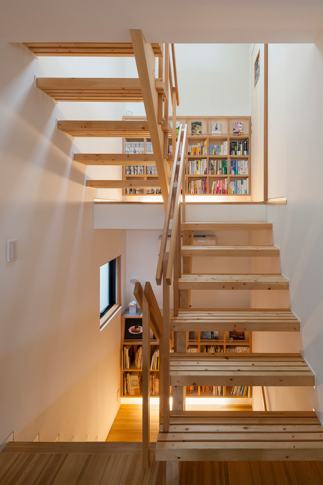 This is an example of a world-inspired wood u-shaped staircase in Tokyo with open risers.