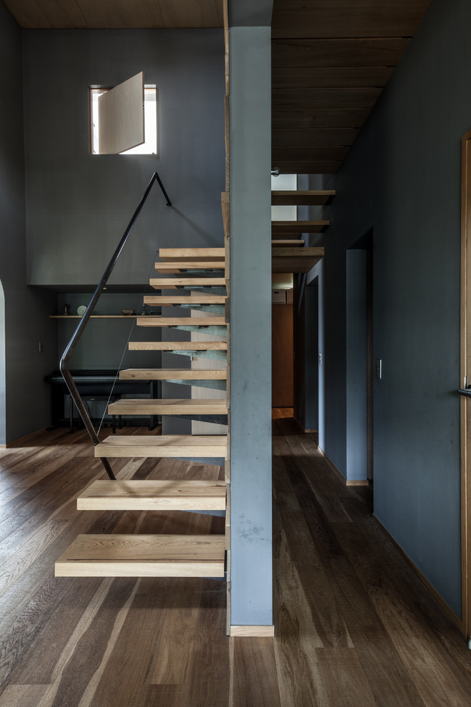 Idées déco pour un escalier sans contremarche droit moderne avec des marches en bois, un garde-corps en métal et éclairage.