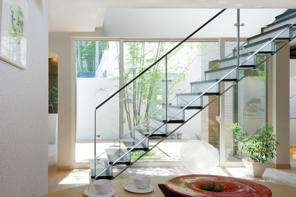 Réalisation d'un escalier nordique en U de taille moyenne avec des marches en bois, des contremarches en verre et éclairage.