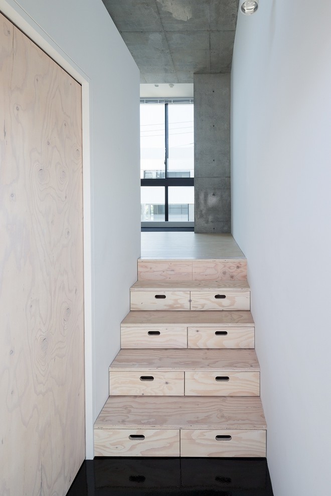 Idée de décoration pour un petit escalier droit minimaliste avec des marches en bois, des contremarches en bois et rangements.