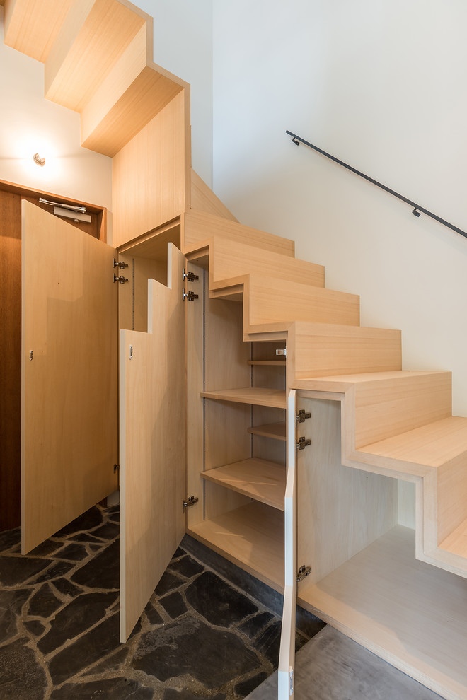 Contemporary wood staircase in Other with wood risers.
