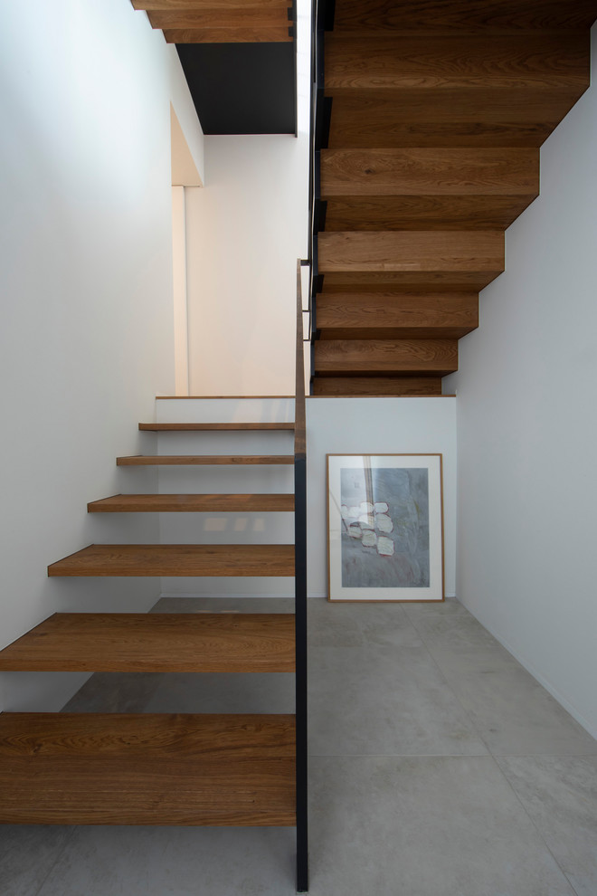 Idées déco pour un escalier sans contremarche industriel en U de taille moyenne avec des marches en bois et un garde-corps en métal.