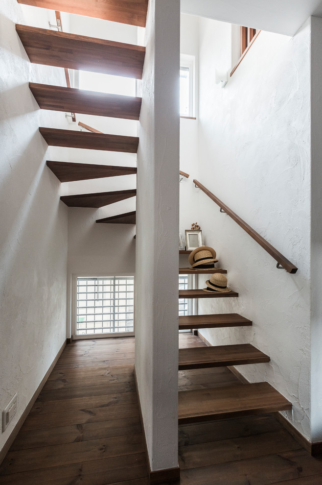 Ejemplo de escalera en U minimalista sin contrahuella con escalones de madera y barandilla de madera